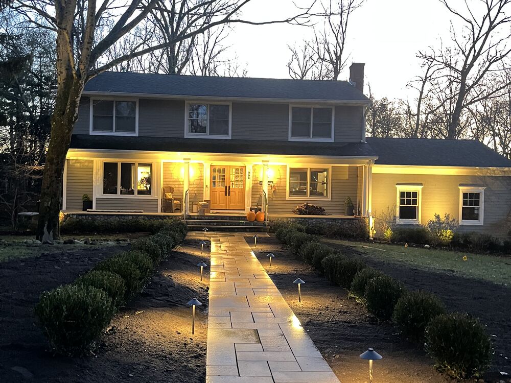 Paver walkway with landscape lighting at dusk